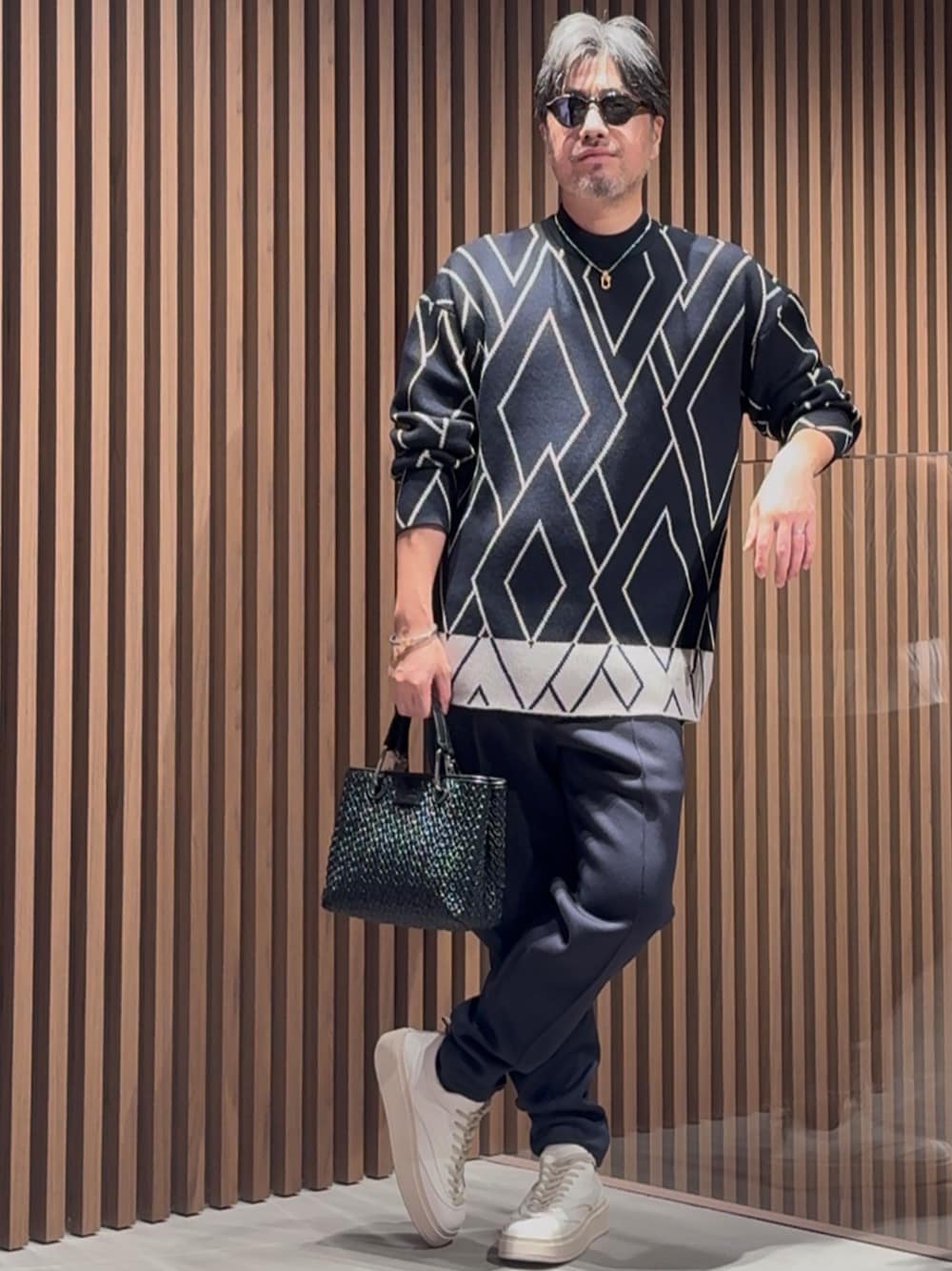 ブルー系のニット/セーター、ブラック系のトートバッグ、ブルー系のその他パンツを着用したメンズの秋コーディネートの1枚目の写真