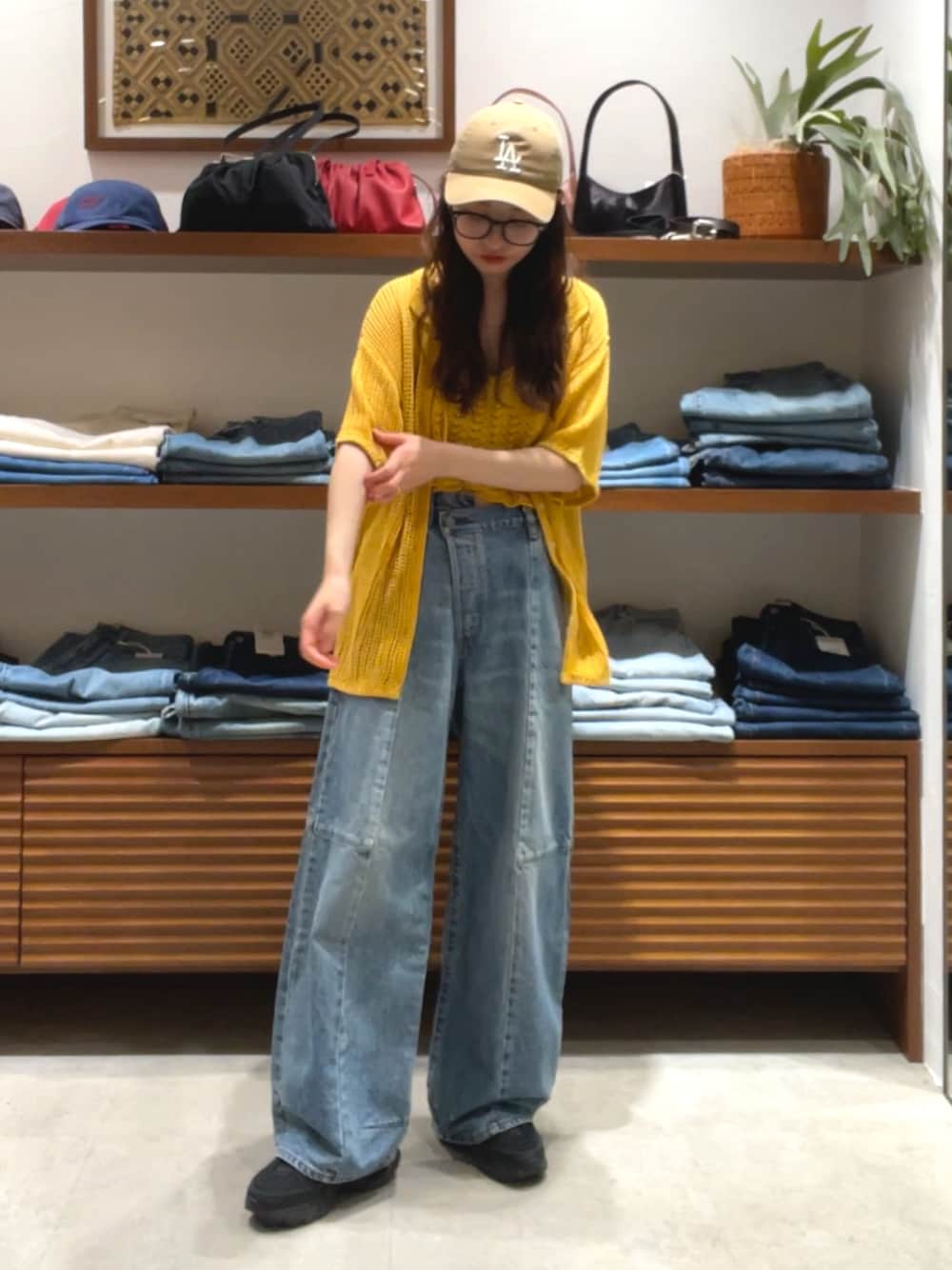 オレンジ系のカーディガン/ボレロ、ブルー系のデニムパンツを着用したレディースの春コーディネートの1枚目の写真