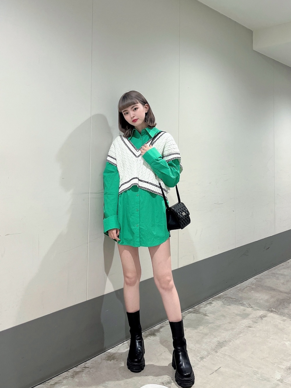 グリーン系のシャツ/ブラウス、ブラック系のショルダーバッグ、ブラック系のブーツを着用したレディースの冬コーディネートの1枚目の写真