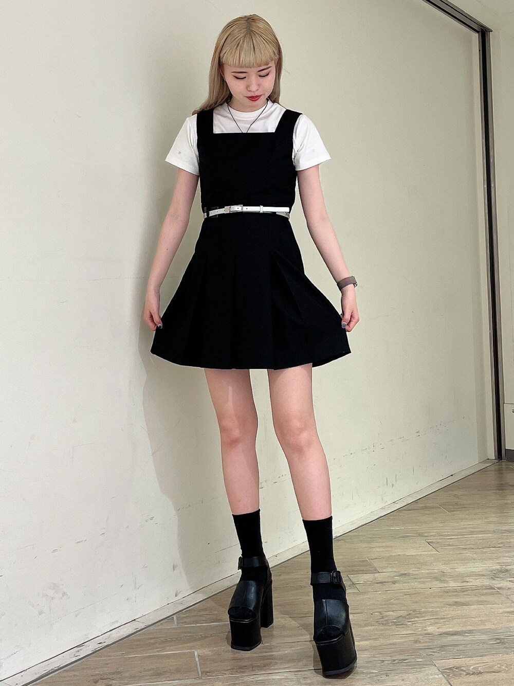 ブラック系のワンピース、ホワイト系のTシャツ/カットソー、ブラック系のサンダルを着用したレディースの春コーディネートの1枚目の写真