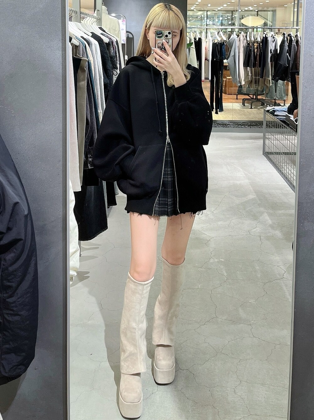 ブラック系のパーカー、その他のスカート、ホワイト系のブーツを着用したレディースの秋コーディネートの1枚目の写真