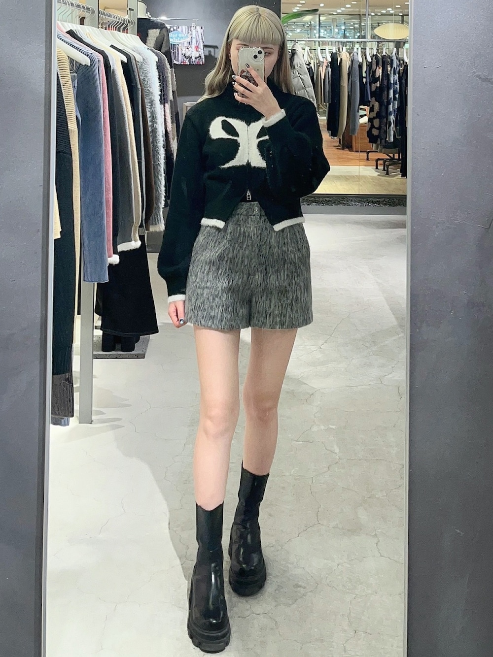 ブラック系のニット/セーター、グレー系のその他パンツ、ブラック系のブーツを着用したレディースの冬コーディネートの1枚目の写真