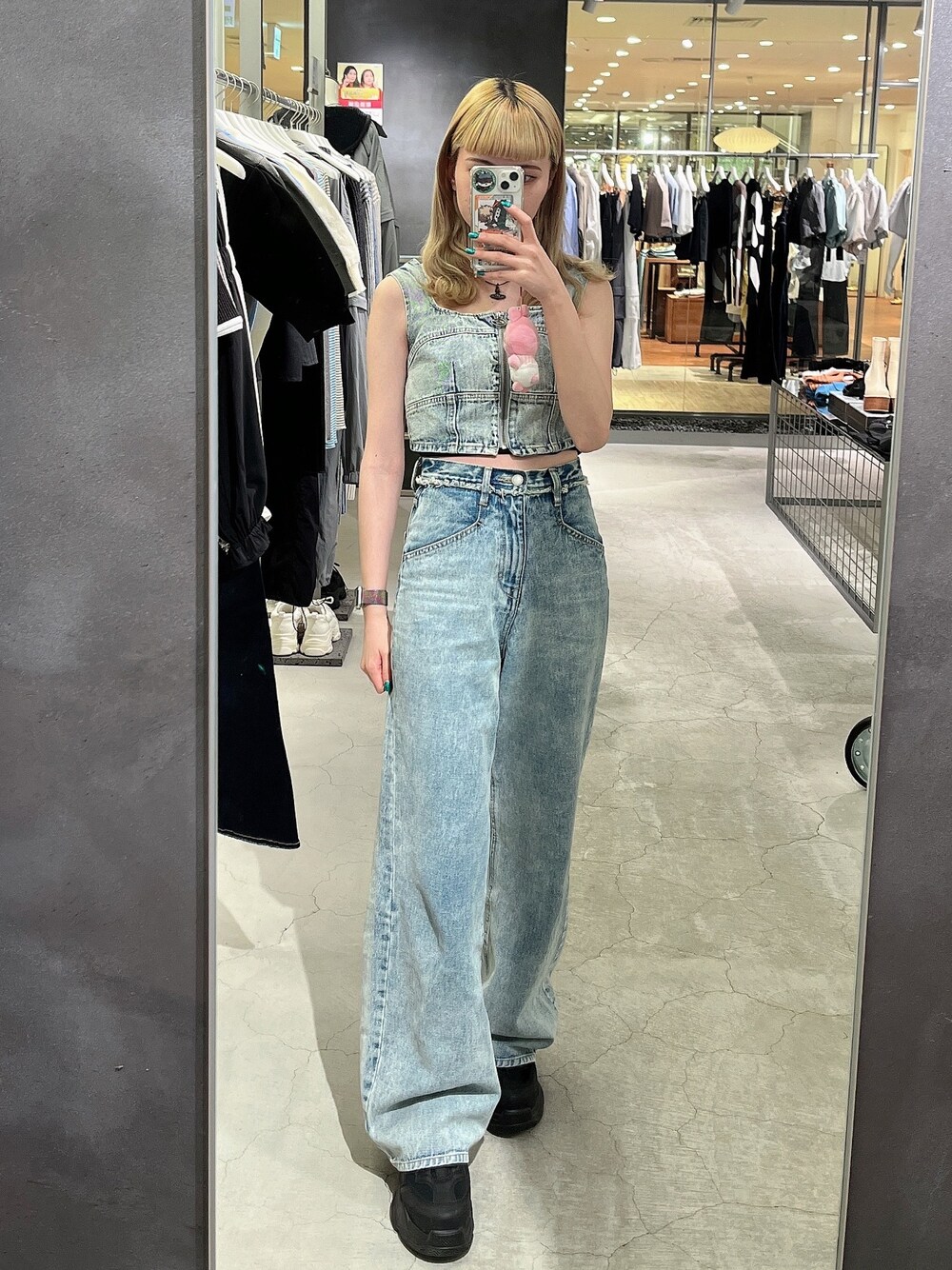 ブルー系のデニムパンツ、ブルー系のキャミソール、ブラック系のスニーカーを着用したレディースの春コーディネートの1枚目の写真