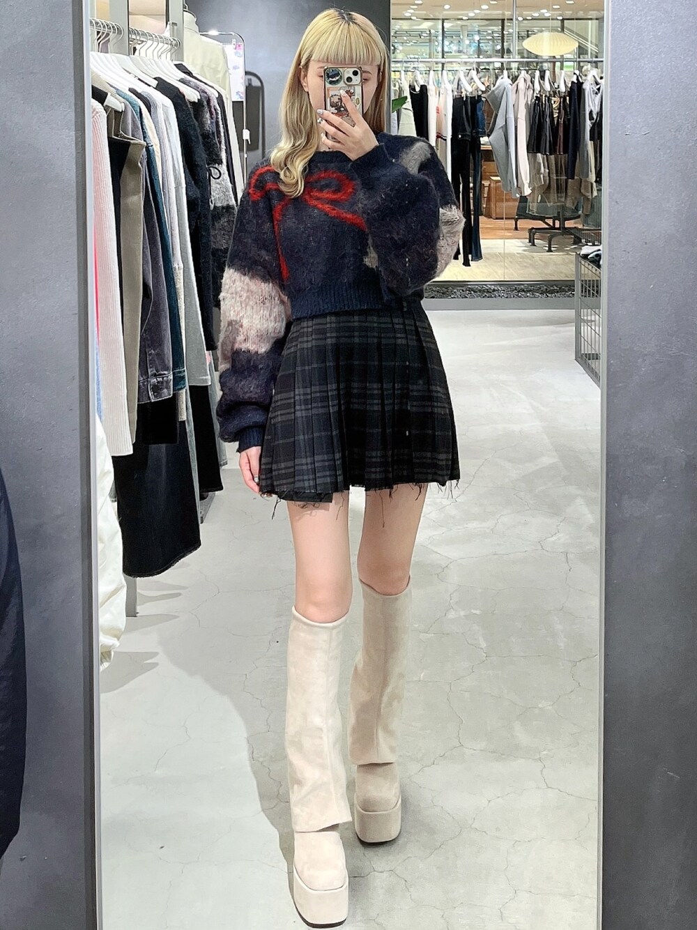 ブルー系のニット/セーター、その他のスカート、ホワイト系のブーツを着用したレディースの秋コーディネートの1枚目の写真