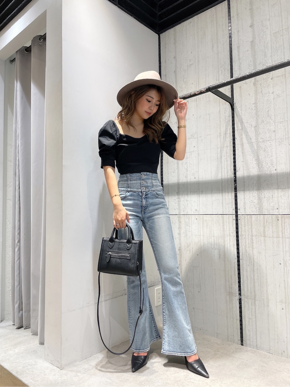 ブラック系のパンプス、ブラック系のシャツ/ブラウス、ブルー系のデニムパンツを着用したレディースの春コーディネートの1枚目の写真