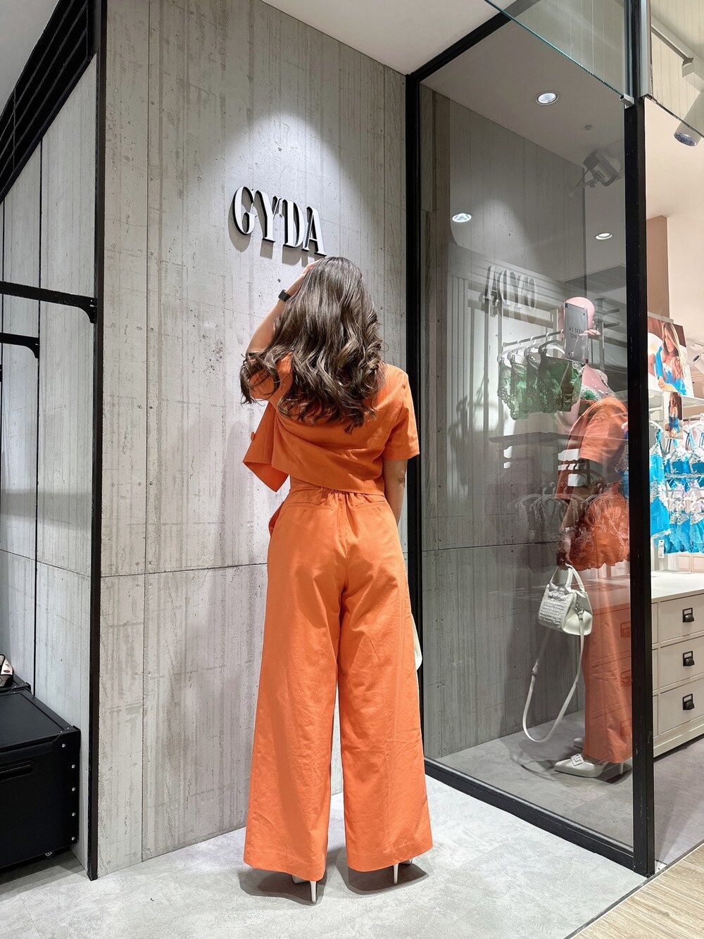 ホワイト系のTシャツ/カットソー、オレンジ系のテーラードジャケット、オレンジ系のスラックスを着用したレディースの春コーディネートの1枚目の写真