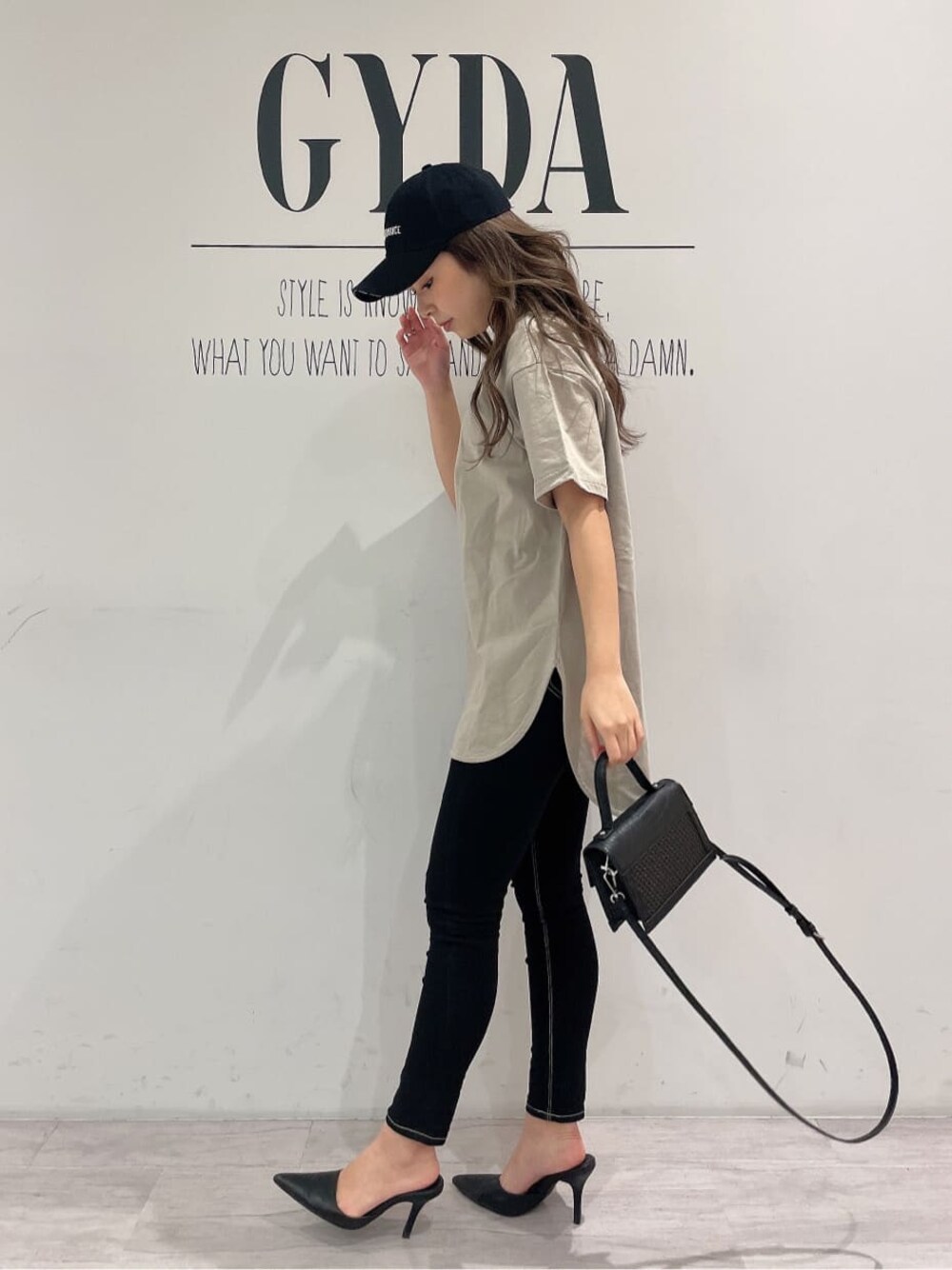 ブラック系のパンプス、ブラック系のデニムパンツ、ブラック系のハンドバッグを着用したレディースの春コーディネートの1枚目の写真