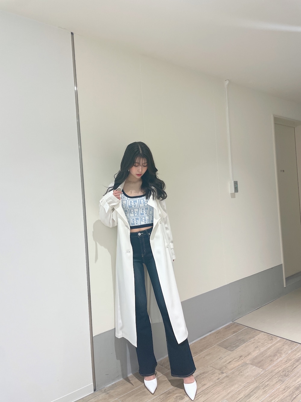 ブルー系のニット/セーター、ホワイト系のトレンチコート、ブルー系のデニムパンツを着用したレディースの春コーディネートの1枚目の写真