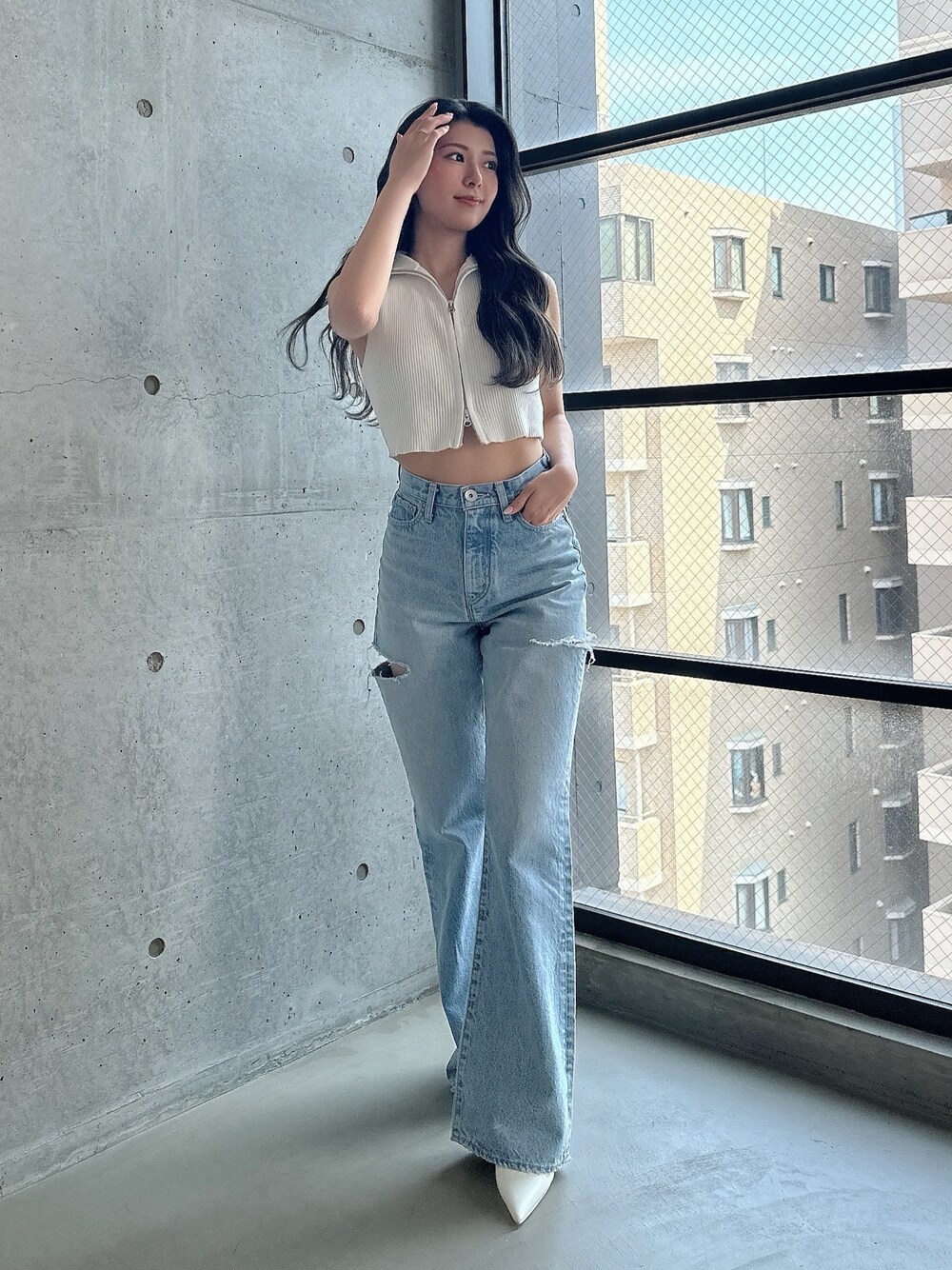 ホワイト系のパンプス、ホワイト系のタンクトップ、ブルー系のデニムパンツを着用したレディースの夏コーディネートの1枚目の写真