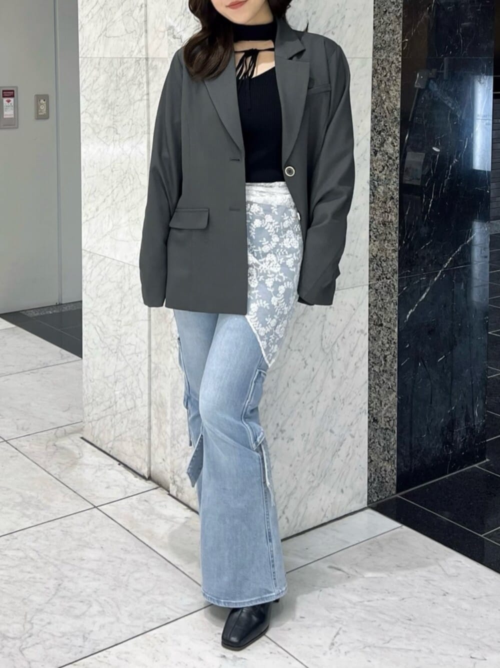 ブラック系のニット/セーター、ブラック系のブーツ、グレー系のテーラードジャケットを着用したレディースの冬コーディネートの1枚目の写真