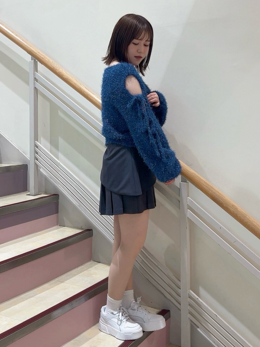 グレー系のスカート、ホワイト系のその他シューズ、ブルー系のニット/セーターを着用したレディースの夏コーディネートの1枚目の写真