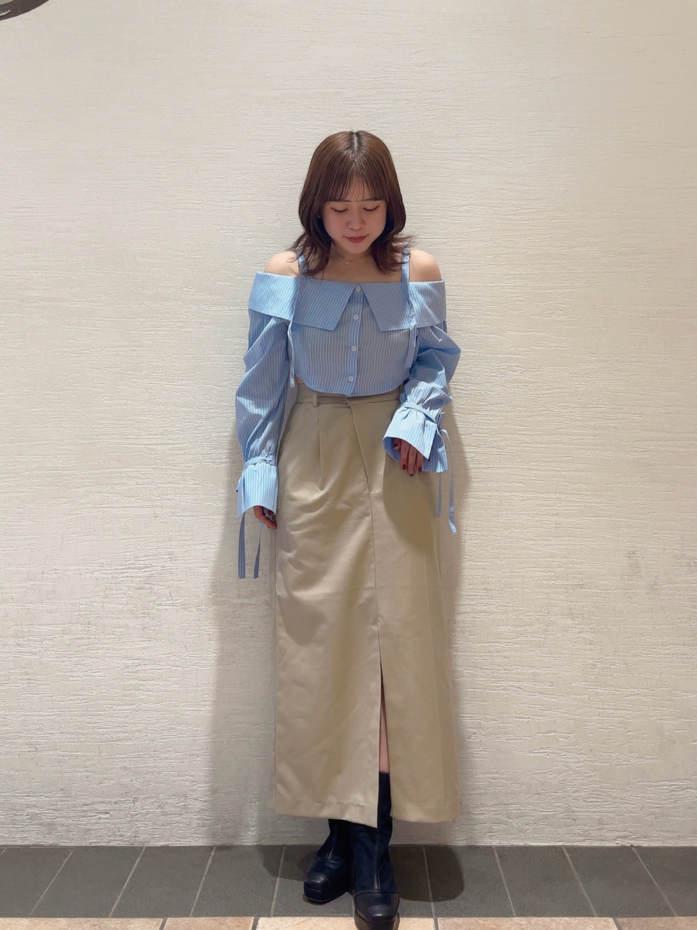 ホワイト系のシャツ/ブラウス、ブラック系のブーツ、グレー系のスカートを着用したレディースの冬コーディネートの1枚目の写真