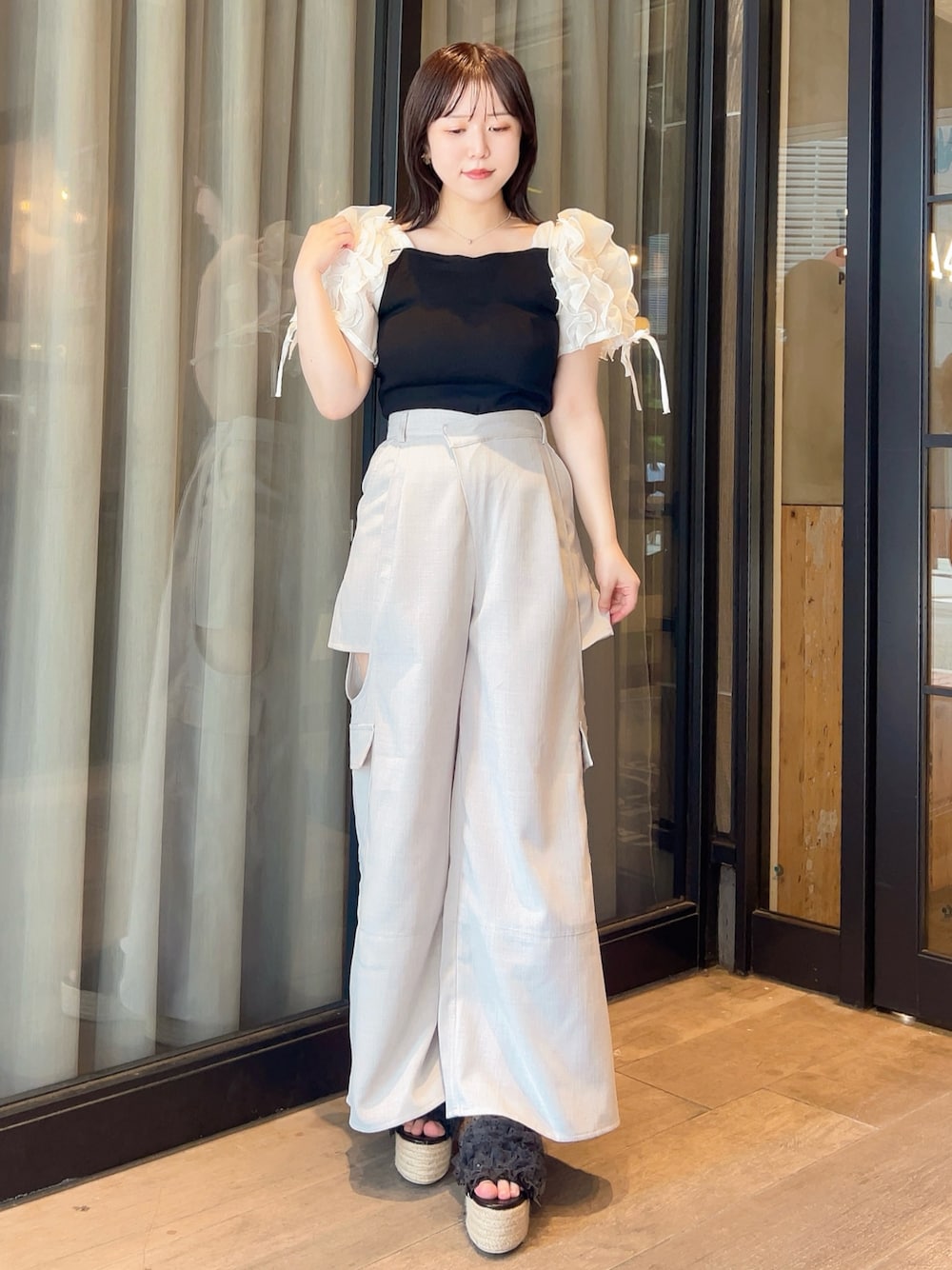 ブラック系のTシャツ/カットソー、グレー系のチノパンツ、ブラック系のサンダルを着用したレディースの夏コーディネートの1枚目の写真