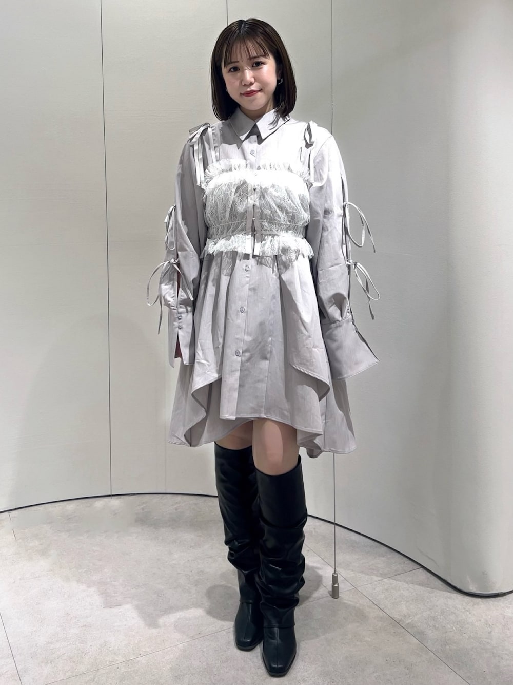 ホワイト系のキャミソール、グレー系のシャツワンピース、ブラック系のブーツを着用したレディースの秋コーディネートの1枚目の写真