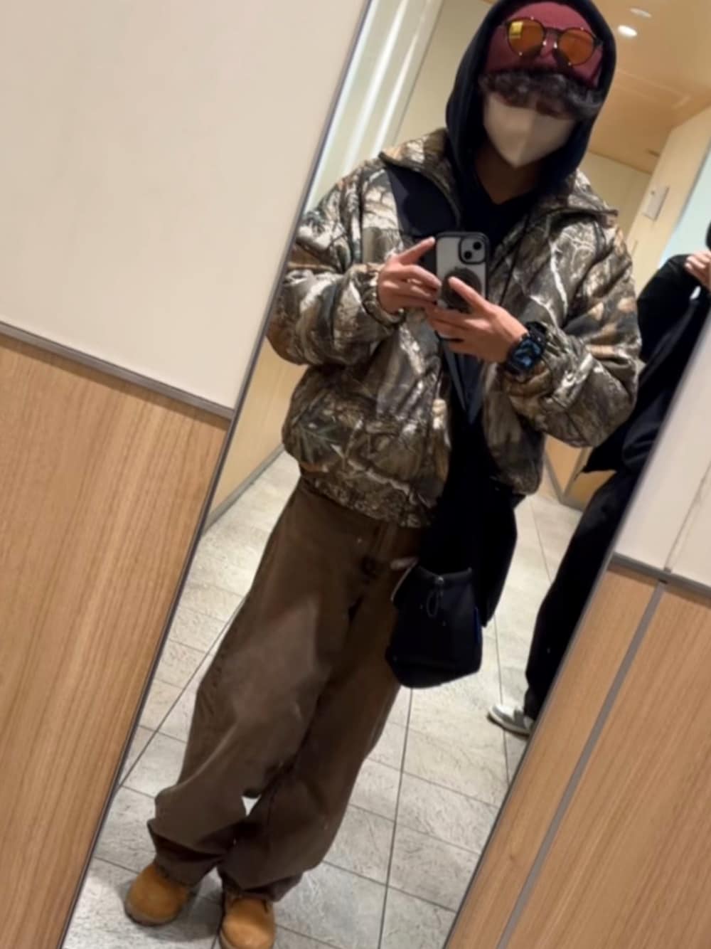 その他のダウンベスト、ブラウン系のデニムパンツ、ブラック系のパーカーを着用したメンズの春コーディネートの1枚目の写真