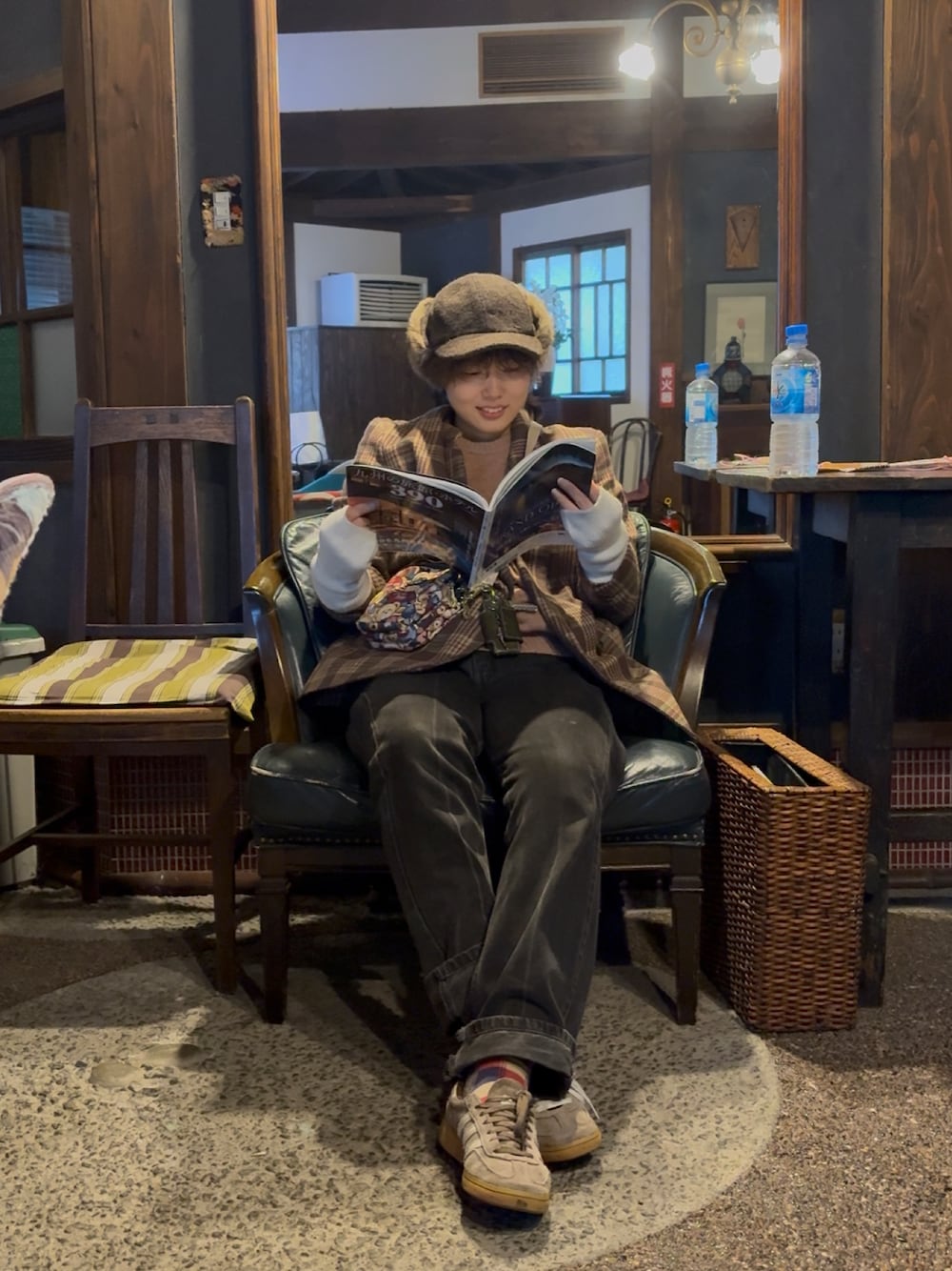 ブラック系のデニムパンツ、ブラウン系のスニーカーを着用したレディースの秋コーディネートの1枚目の写真