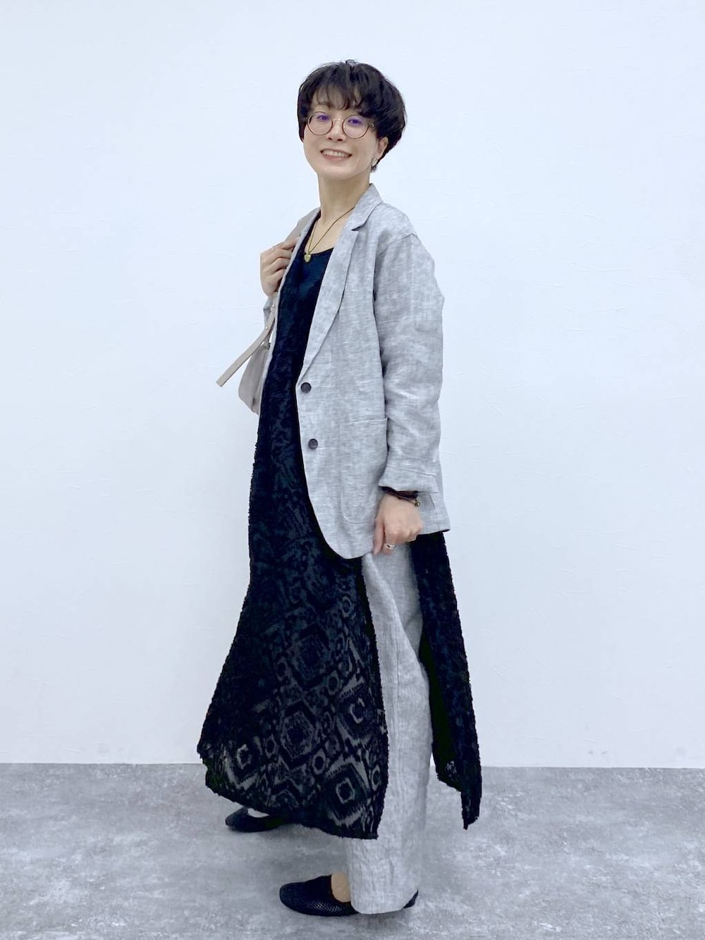 ブラック系のTシャツ/カットソー、ブラック系のベスト、グレー系のショルダーバッグを着用したレディースの春コーディネートの1枚目の写真