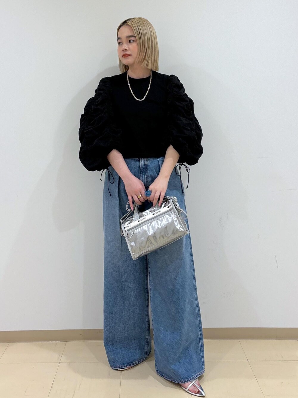ブルー系のデニムパンツ、シルバー系のショルダーバッグ、シルバー系のサンダルを着用したレディースの春コーディネートの1枚目の写真