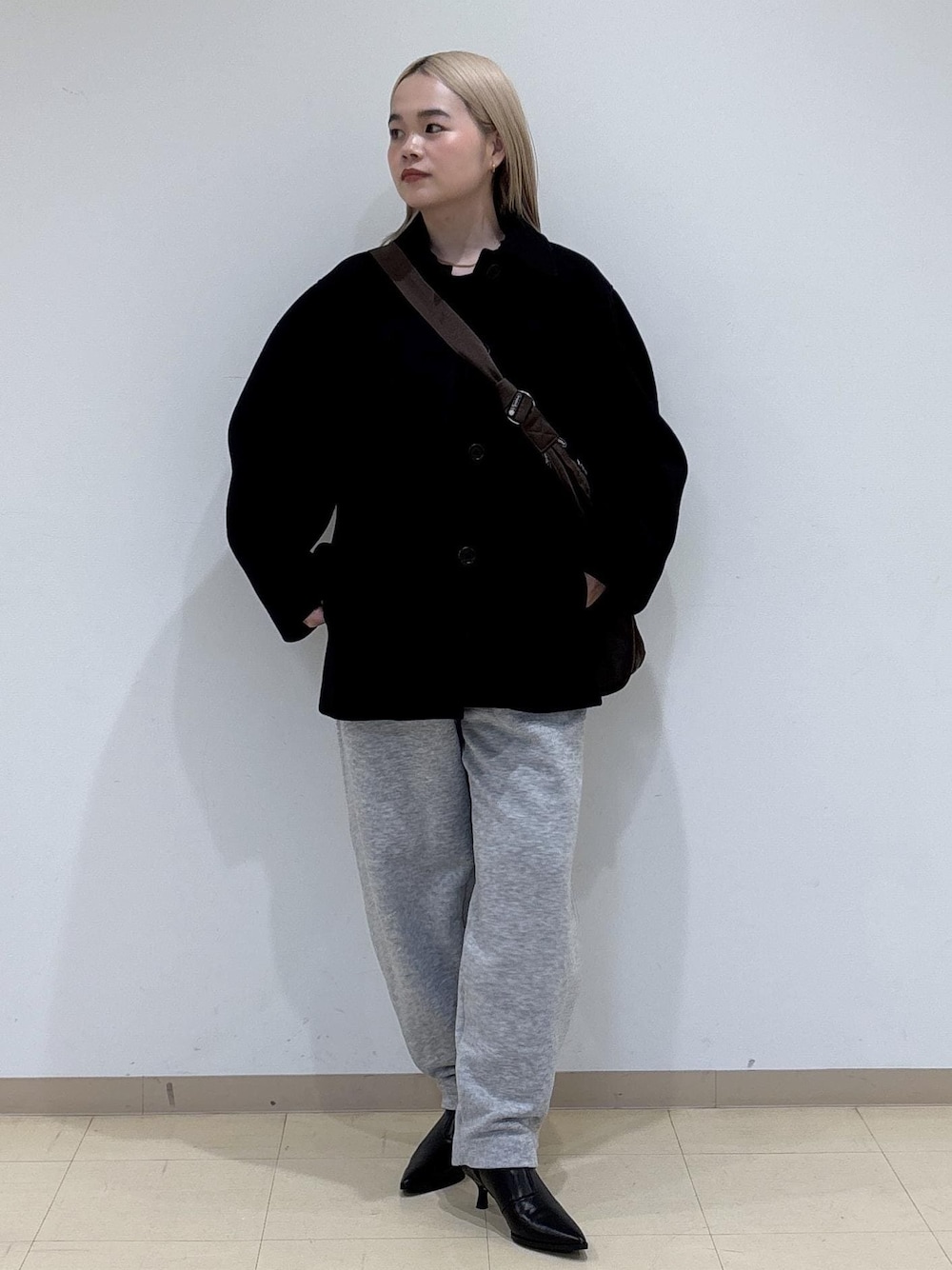 ブラック系のブーツ、グレー系のその他パンツ、ブラウン系のショルダーバッグを着用したレディースの冬コーディネートの1枚目の写真