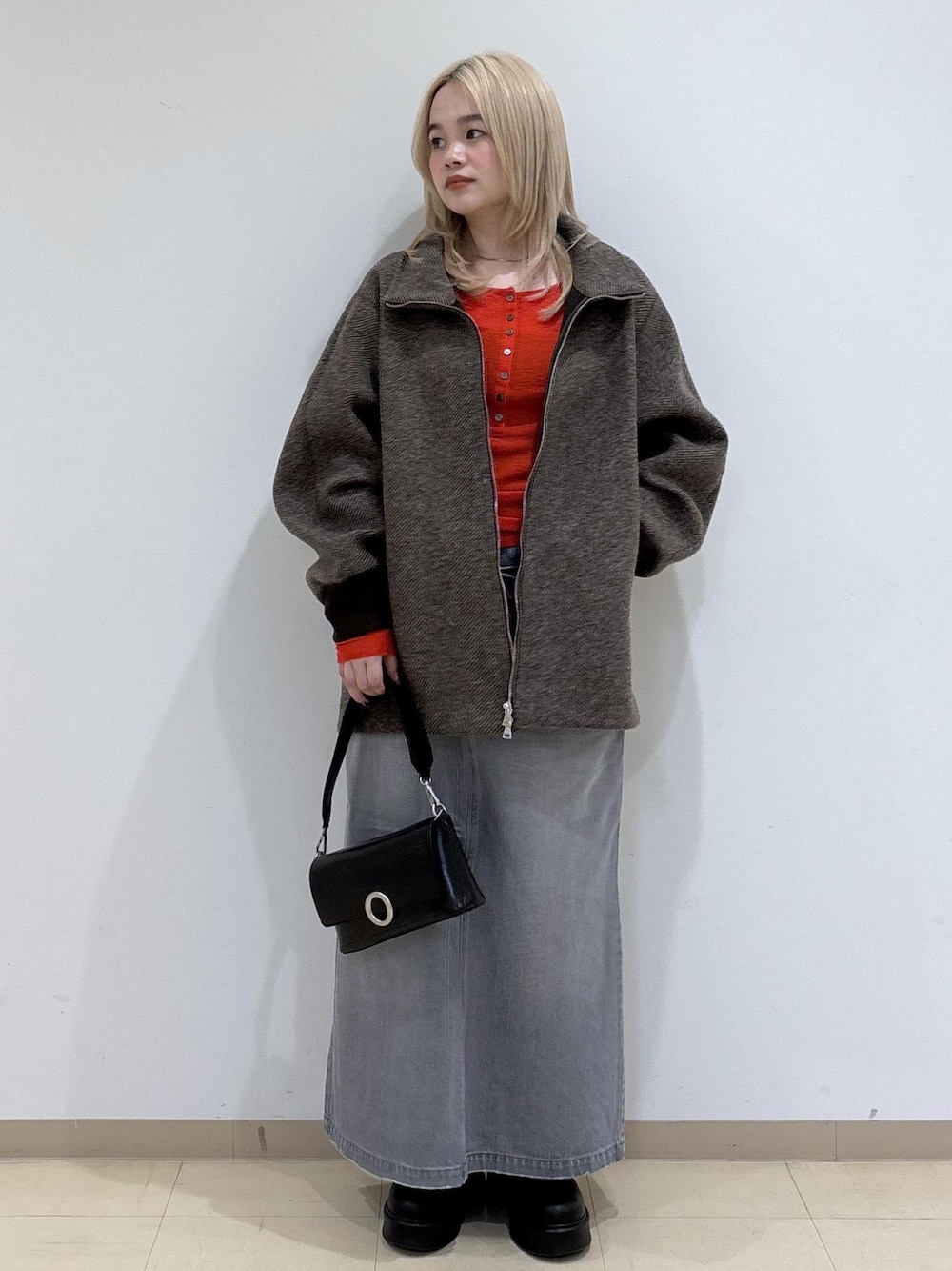 グレー系のデニムスカート、ブラウン系のその他アウター、レッド系のTシャツ/カットソーを着用したレディースの秋コーディネートの1枚目の写真