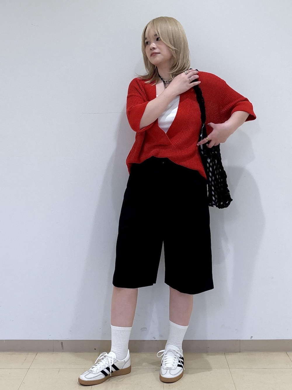 ブラック系のトートバッグ、ブラック系のその他パンツ、レッド系のニット/セーターを着用したレディースの春コーディネートの1枚目の写真