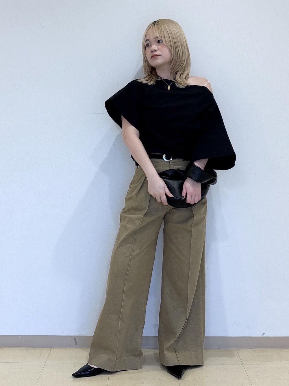 ブラック系のパンプス、ブラック系のショルダーバッグ、ベージュ系のデニムパンツを着用したレディースの春コーディネートの1枚目の写真