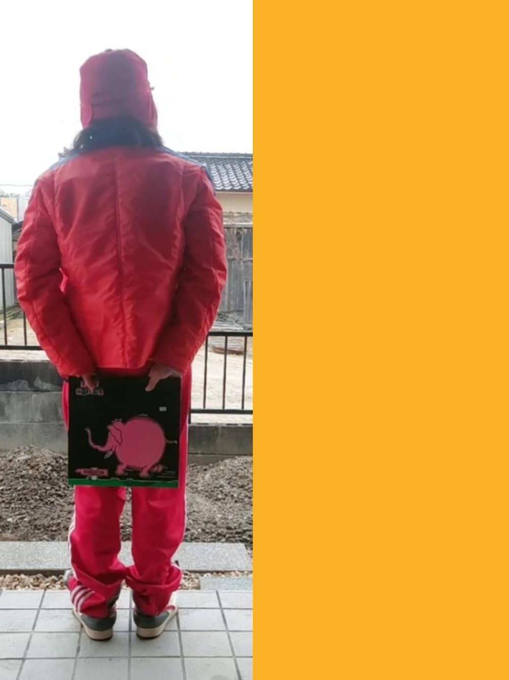 レッド系のナイロンジャケット、イエロー系のTシャツ/カットソー、グレー系のTシャツ/カットソーを着用したメンズの冬コーディネートの2枚目の写真