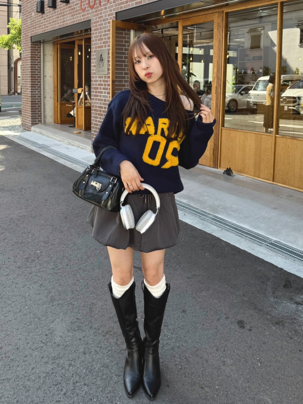 ブルー系のニット/セーター、グレー系のパンツ、ブラック系のバッグを着用したレディースの秋コーディネートの1枚目の写真