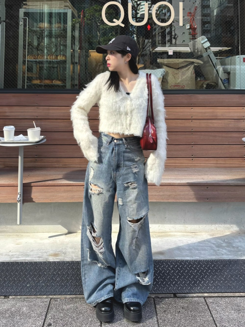 ホワイト系のカーディガン/ボレロ、レッド系のショルダーバッグ、ブルー系のデニムパンツを着用したレディースの秋コーディネートの1枚目の写真