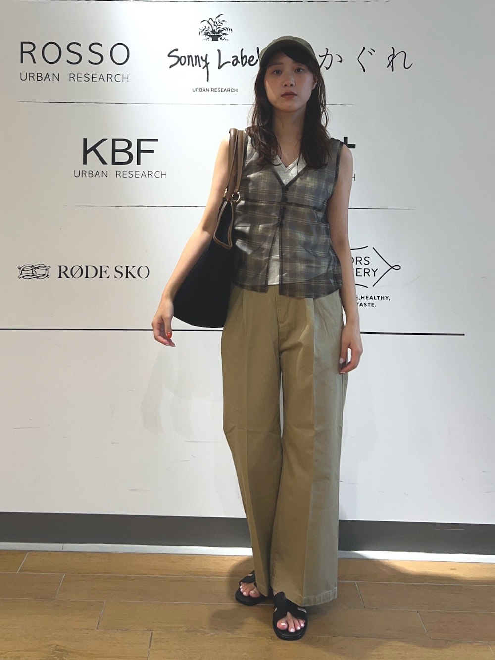 ベージュ系のその他パンツ、ブラック系のトートバッグ、ブラウン系のキャップを着用したレディースの夏コーディネートの1枚目の写真
