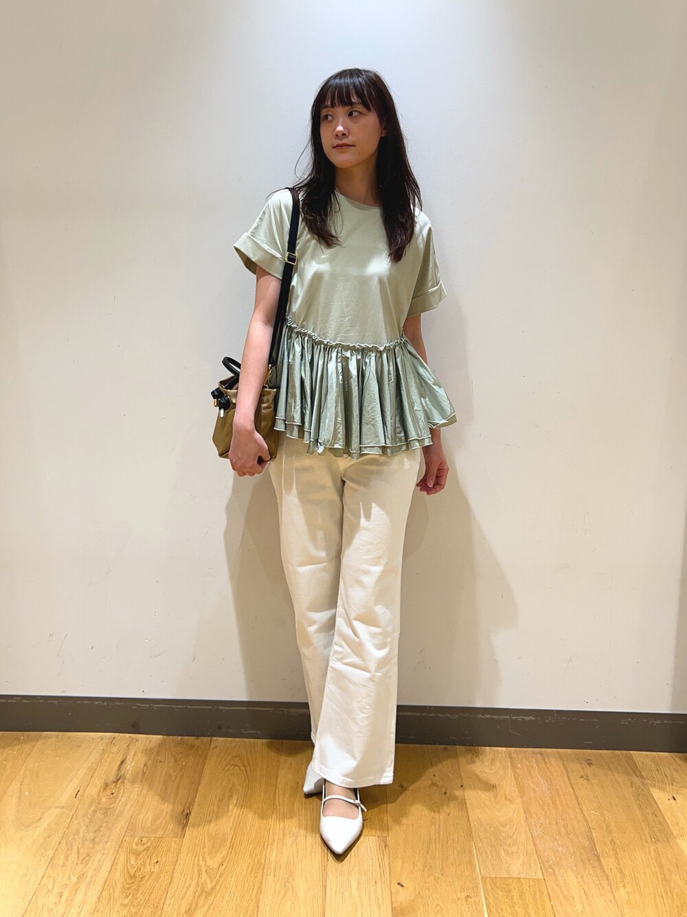 グリーン系のTシャツ/カットソー、ベージュ系のショルダーバッグ、ホワイト系のデニムパンツを着用したレディースの春コーディネートの1枚目の写真