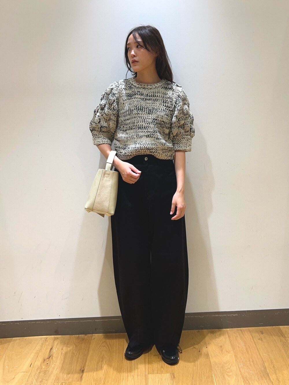 ホワイト系のニット/セーター、ブラック系のその他パンツ、ベージュ系のショルダーバッグを着用したレディースの秋コーディネートの1枚目の写真