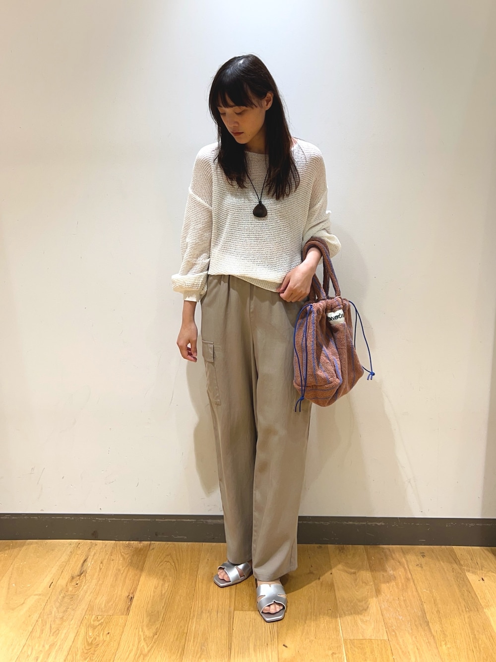 ホワイト系のニット/セーター、ベージュ系のその他パンツ、シルバー系のサンダルを着用したレディースの春コーディネートの1枚目の写真