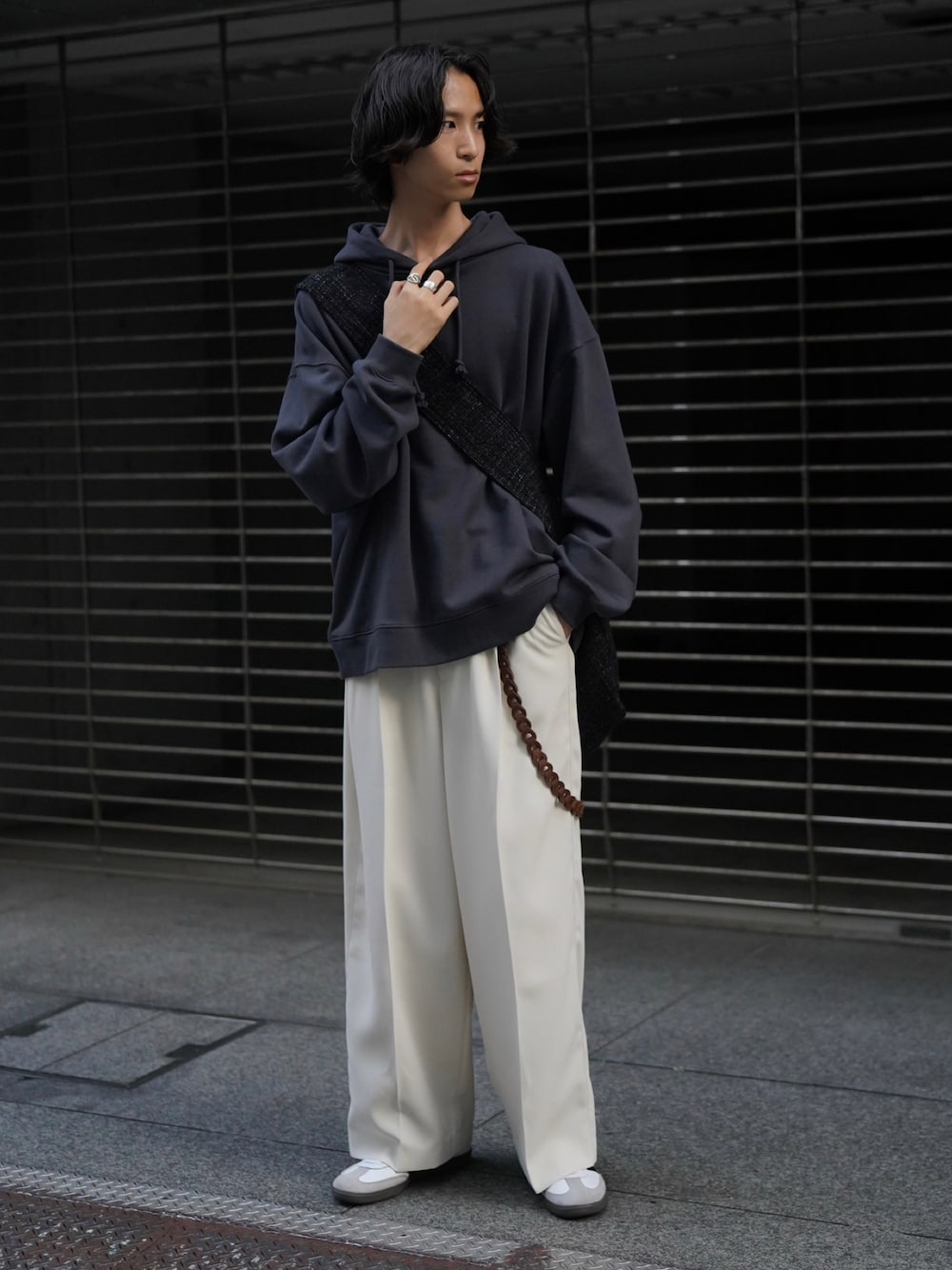 ブルー系のパーカー、ホワイト系のスラックス、ホワイト系のスニーカーを着用したメンズの秋コーディネートの1枚目の写真