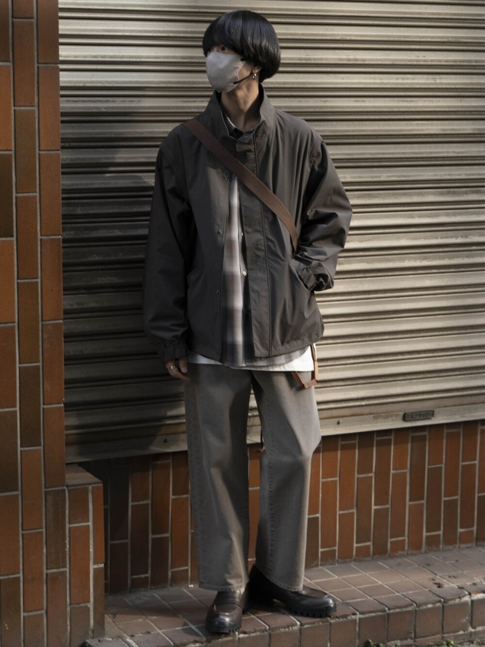 グレー系のブルゾン、ブラウン系のシャツ/ブラウス、ホワイト系のタンクトップを着用したメンズの春コーディネートの1枚目の写真