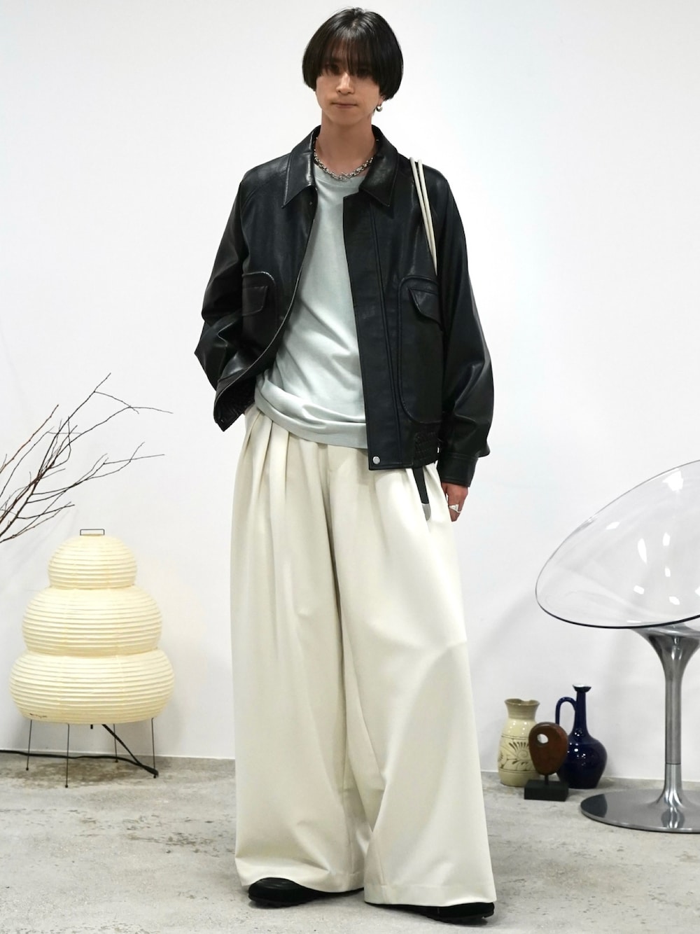 グリーン系のTシャツ/カットソー、ブラック系のブルゾン、ホワイト系のスラックスを着用したメンズの秋コーディネートの1枚目の写真