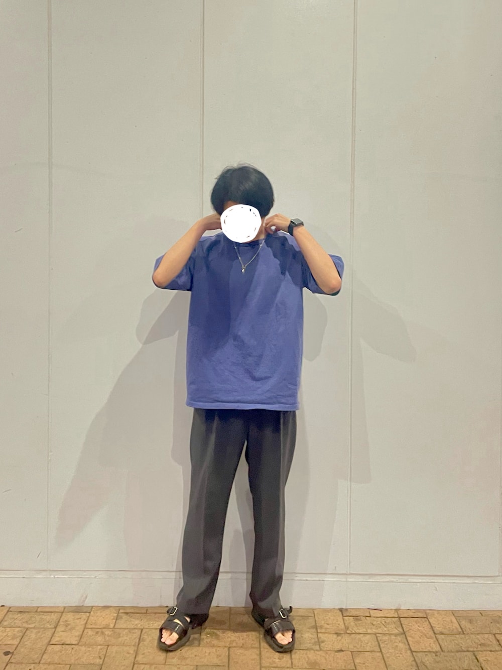ブルー系のTシャツ/カットソー、グレー系のスラックス、ブラック系のサンダルを着用したメンズの夏コーディネートの1枚目の写真