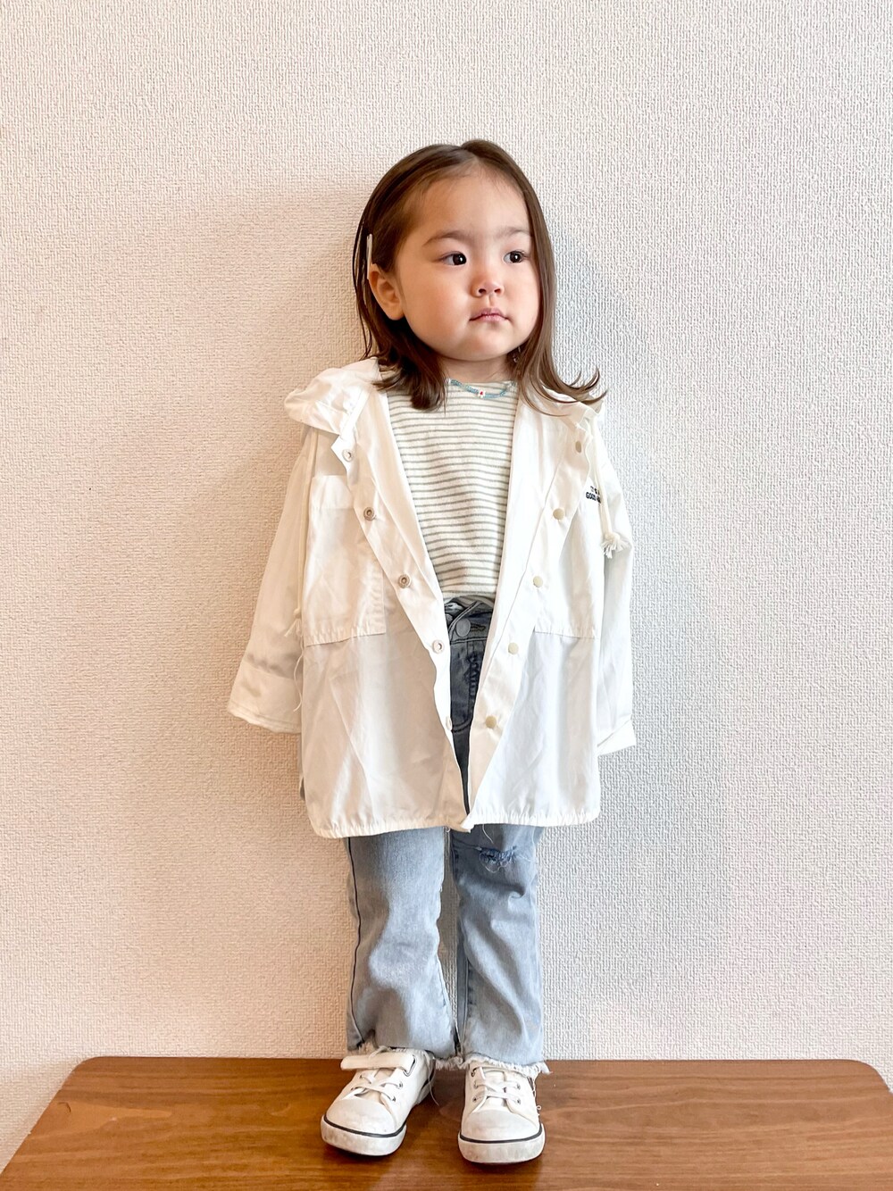 ホワイト系のマウンテンパーカー、グリーン系のTシャツ/カットソー、ブルー系のデニムパンツを着用したキッズの春コーディネートの1枚目の写真