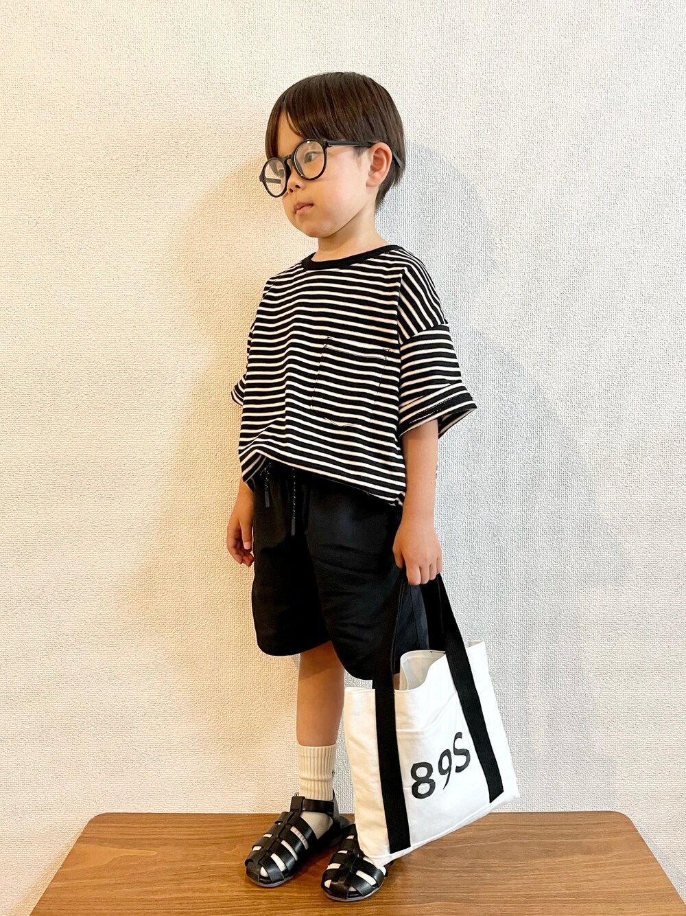 ブラック系のTシャツ/カットソー、ブラック系のその他パンツ、ホワイト系のハンドバッグを着用したキッズの夏コーディネートの1枚目の写真