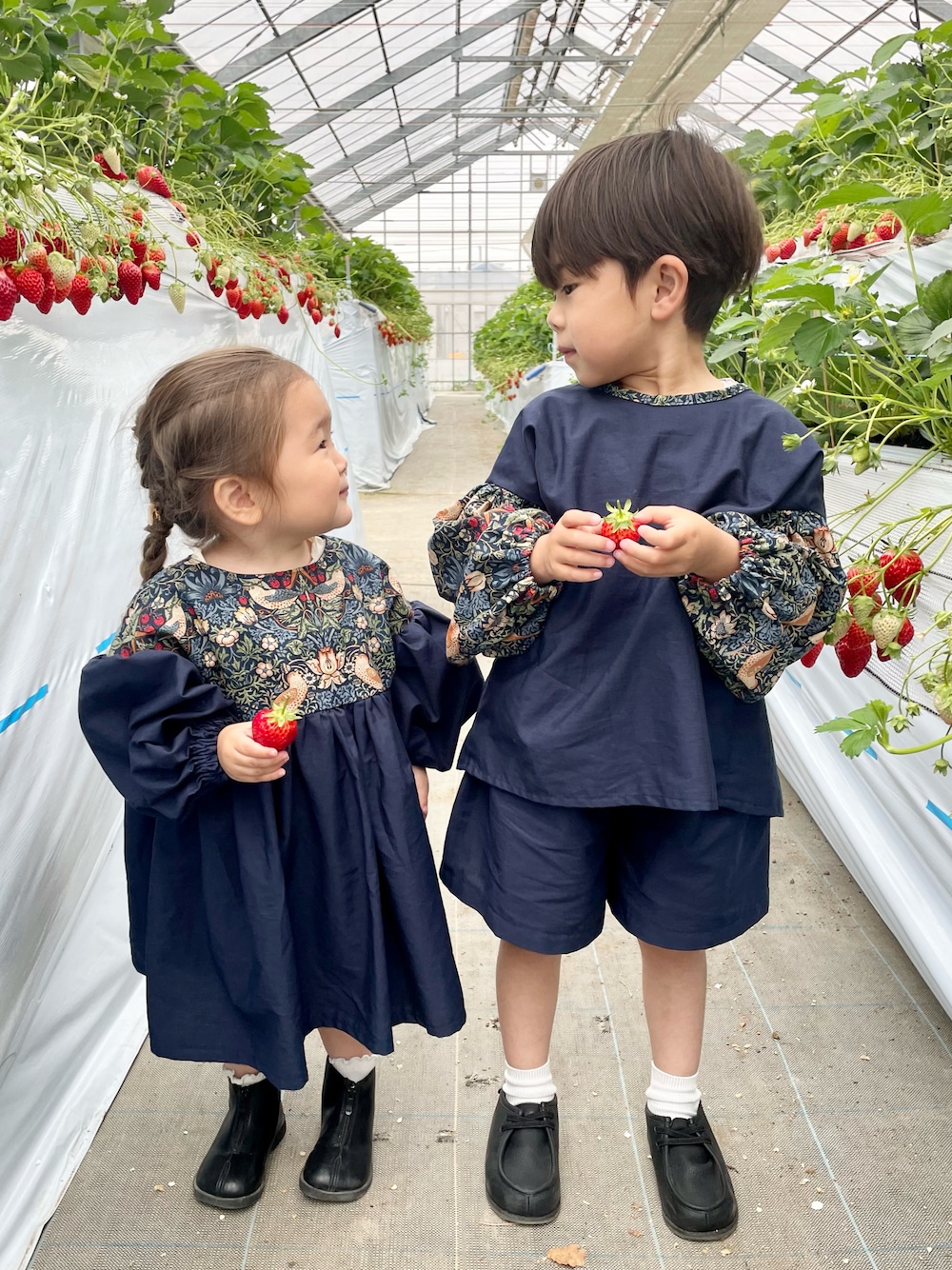 ブルー系のワンピース、ブラック系のブーツ、ブルー系のシャツ/ブラウスを着用したキッズの春コーディネートの1枚目の写真