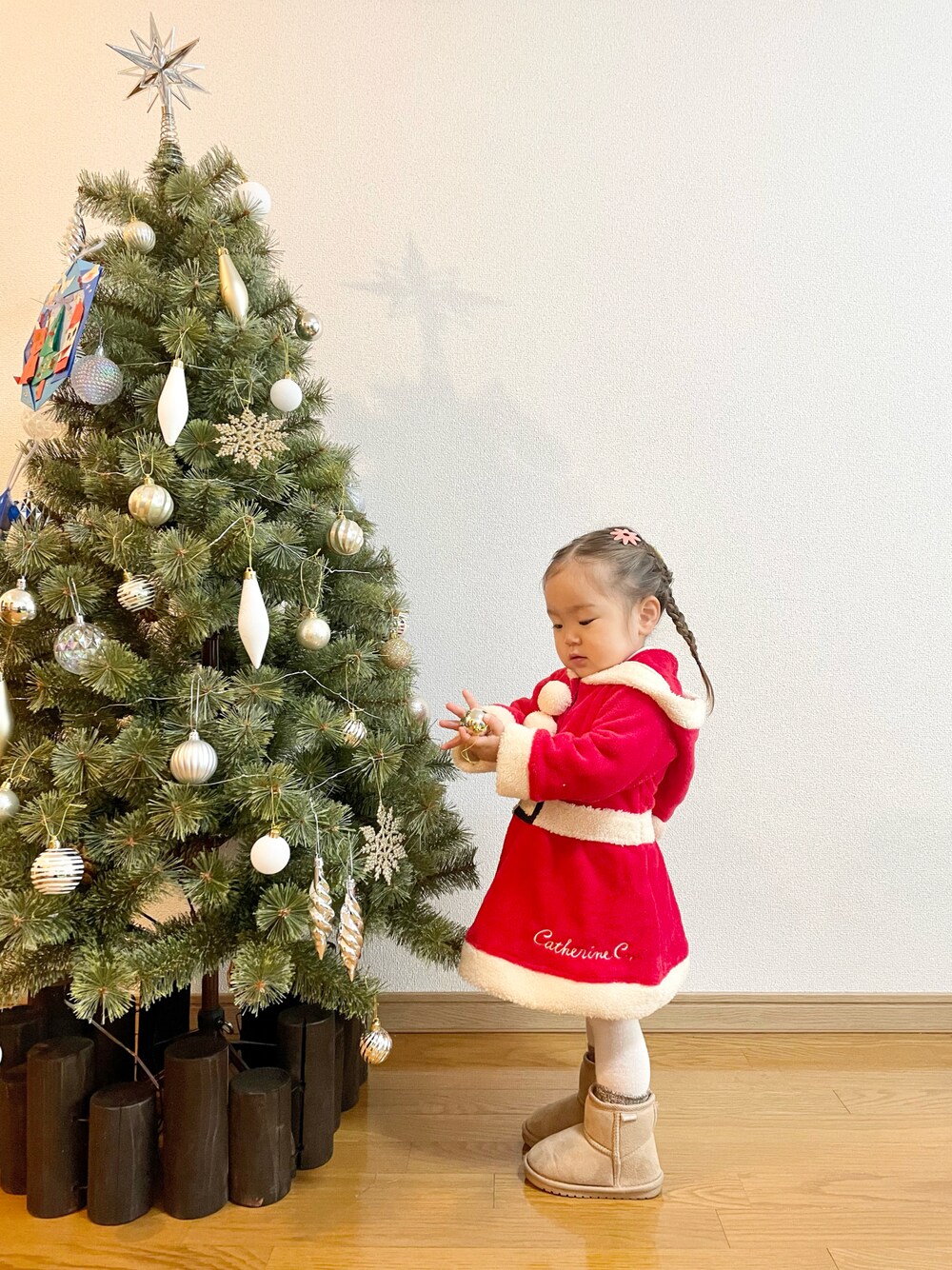 ベージュ系のTシャツ/カットソー、レッド系のワンピース、ベージュ系のブーツを着用したキッズの冬コーディネートの1枚目の写真