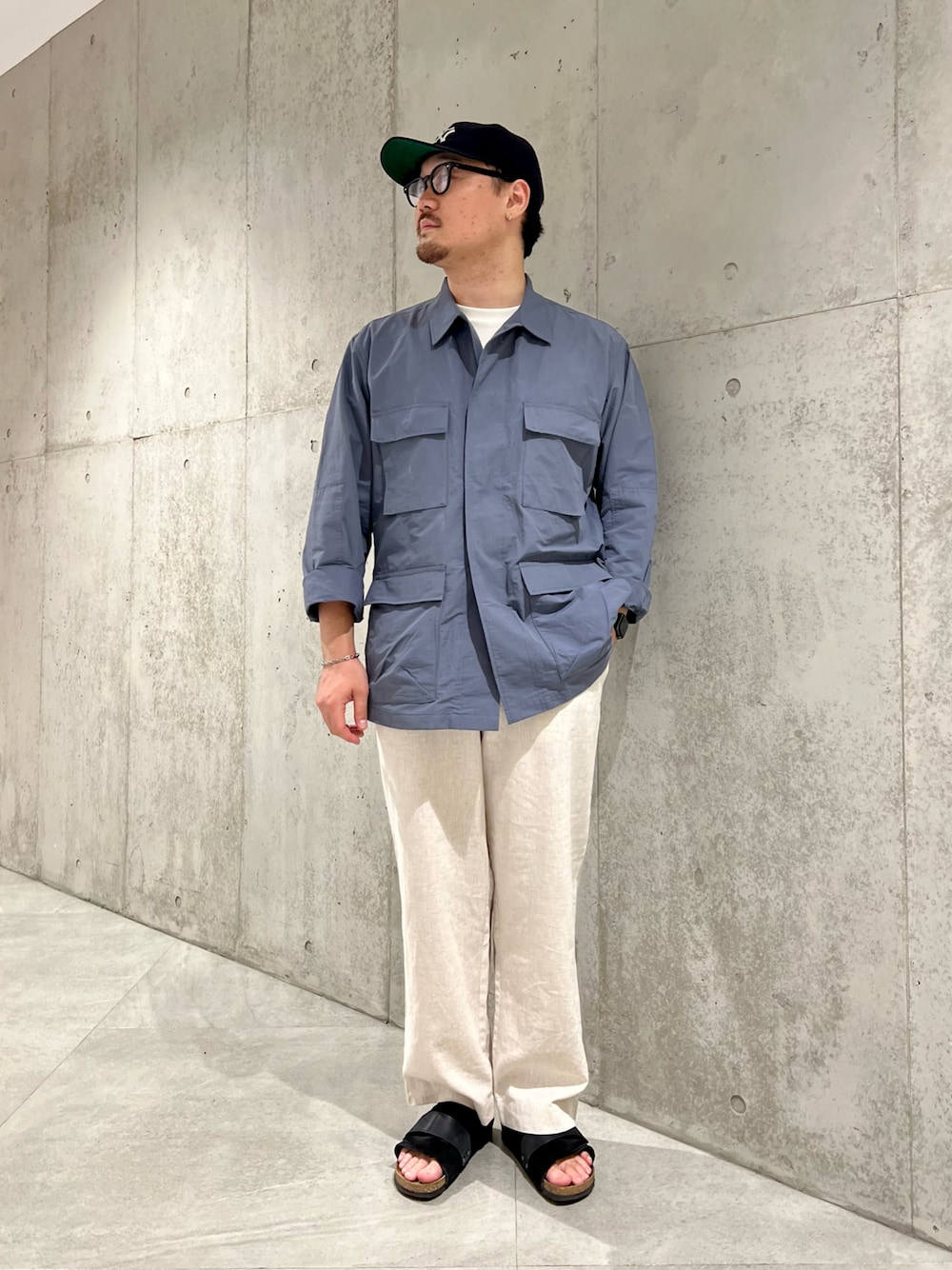 ホワイト系のTシャツ/カットソー、ブラック系のサンダル、グレー系のその他アウターを着用したメンズの秋コーディネートの1枚目の写真