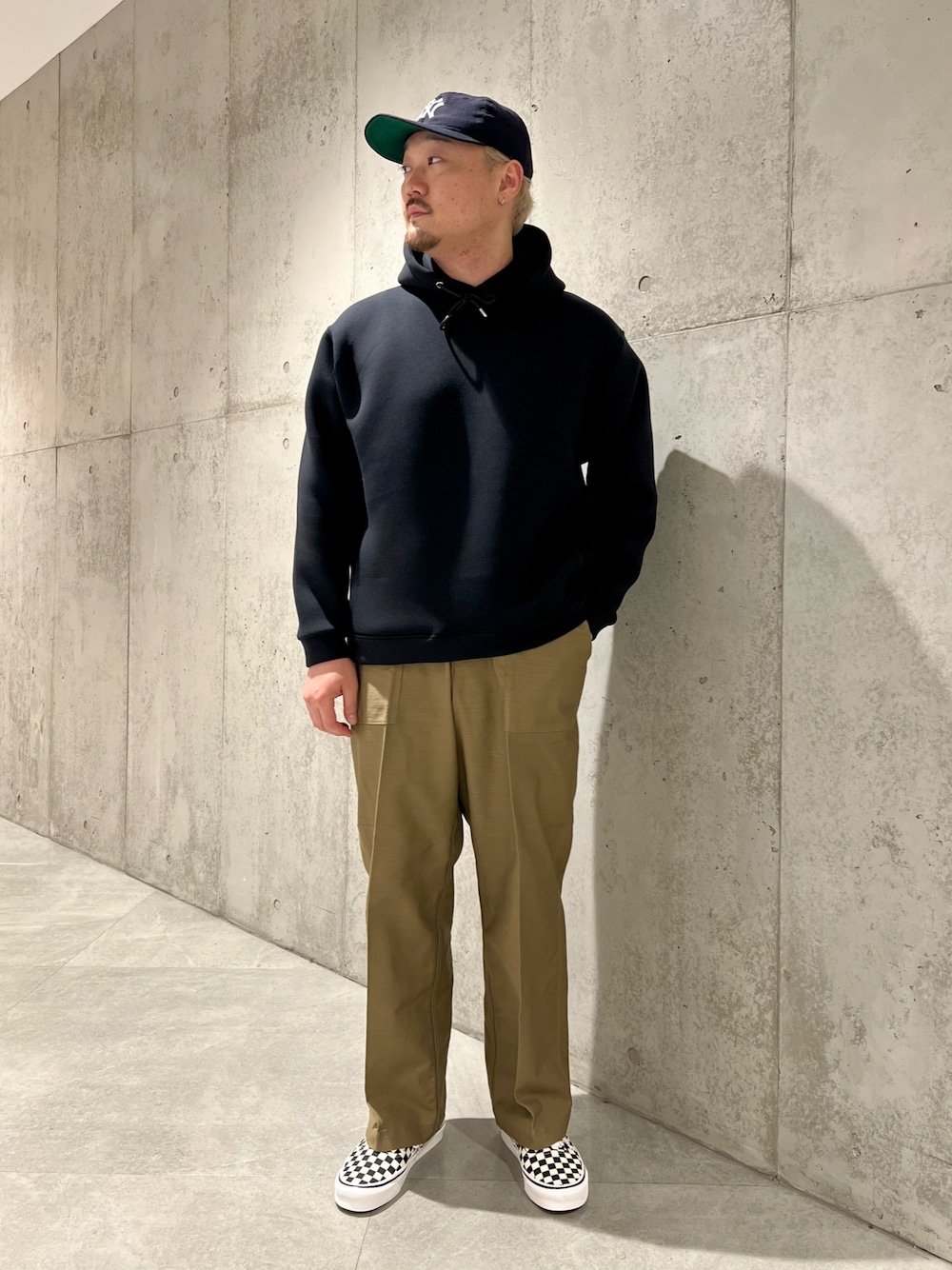 ブラック系のパーカー、グリーン系のその他パンツ、ブラック系のスニーカーを着用したメンズの秋コーディネートの1枚目の写真