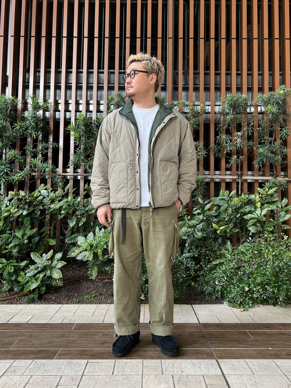ベージュ系のブルゾン、ホワイト系のTシャツ/カットソー、グリーン系のカーゴパンツを着用したメンズの冬コーディネートの1枚目の写真