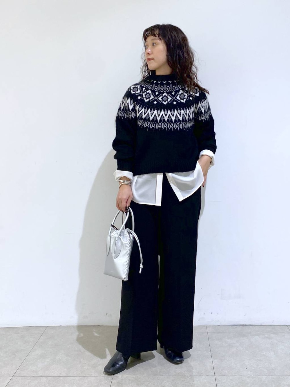 シルバー系のショルダーバッグ、ブラック系のTシャツ/カットソー、ホワイト系のシャツ/ブラウスを着用したレディースの冬コーディネートの1枚目の写真