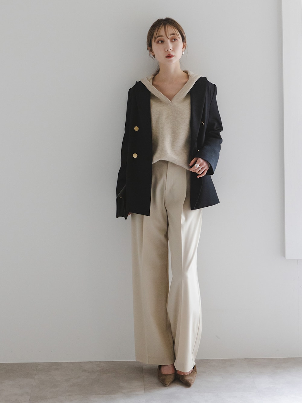 ブラック系のテーラードジャケット、ホワイト系のニット/セーター、ベージュ系のスラックスを着用したレディースの冬コーディネートの1枚目の写真