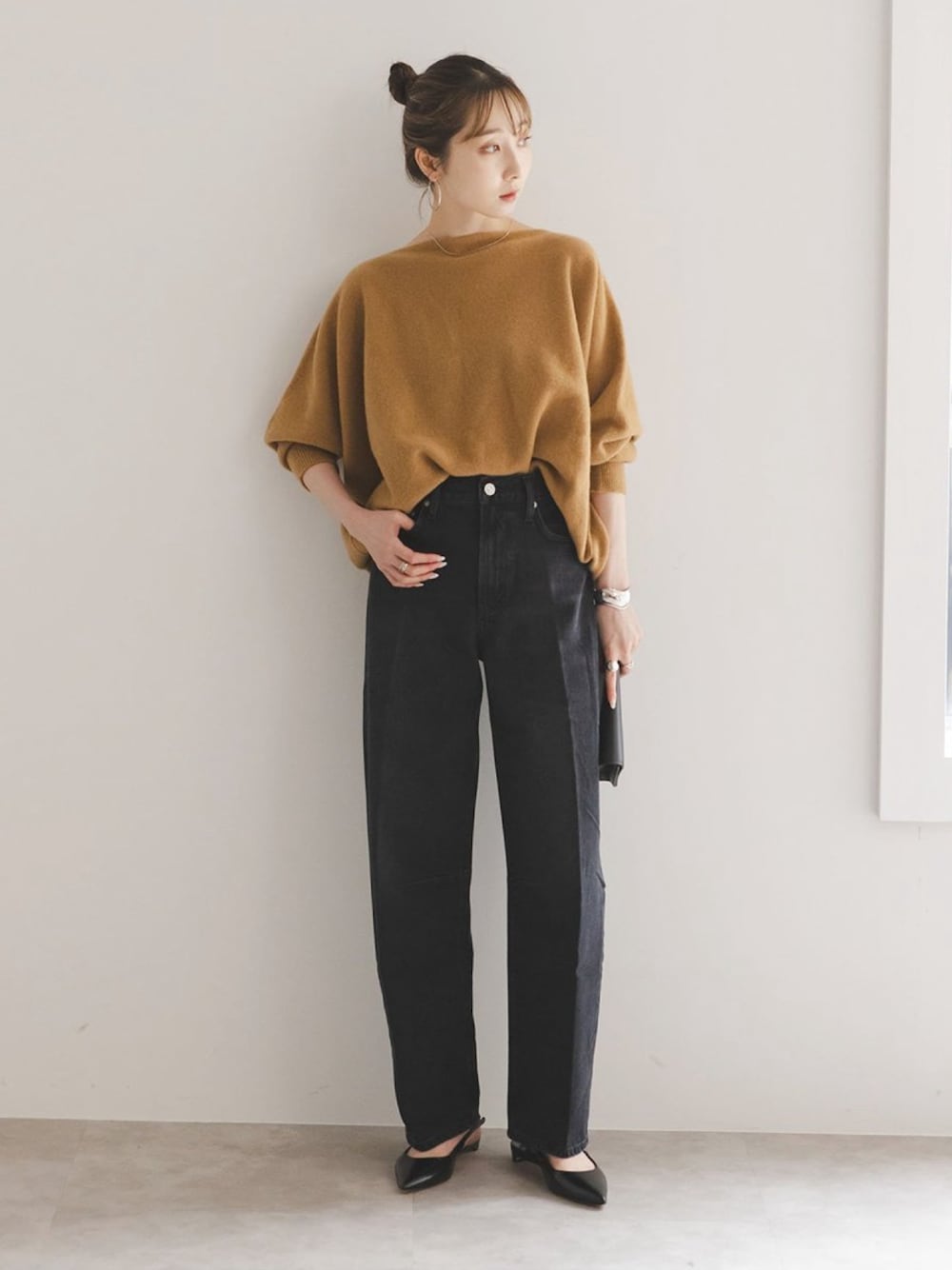イエロー系のニット/セーター、ブラック系のデニムパンツ、ブラック系のパンプスを着用したレディースの秋コーディネートの1枚目の写真