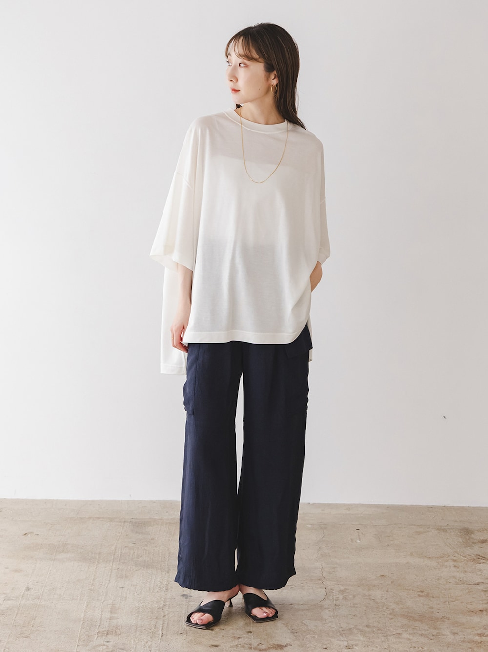 ホワイト系のTシャツ/カットソー、ブルー系のカーゴパンツ、ブラック系のサンダルを着用したレディースの春コーディネートの1枚目の写真