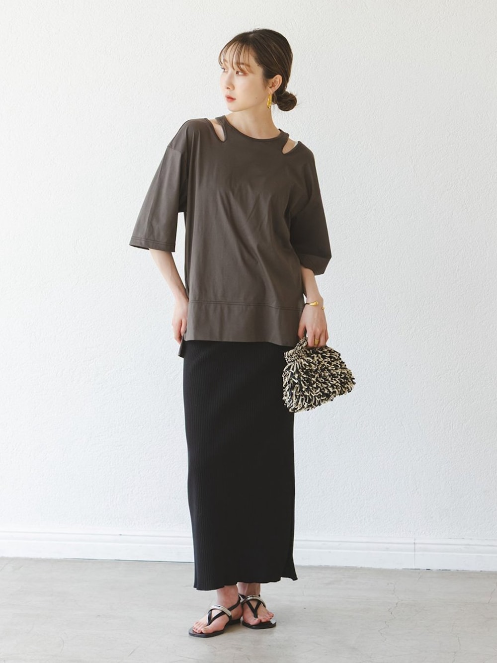 グリーン系のTシャツ/カットソー、ブラック系のスカート、ブラック系のサンダルを着用したレディースの夏コーディネートの1枚目の写真