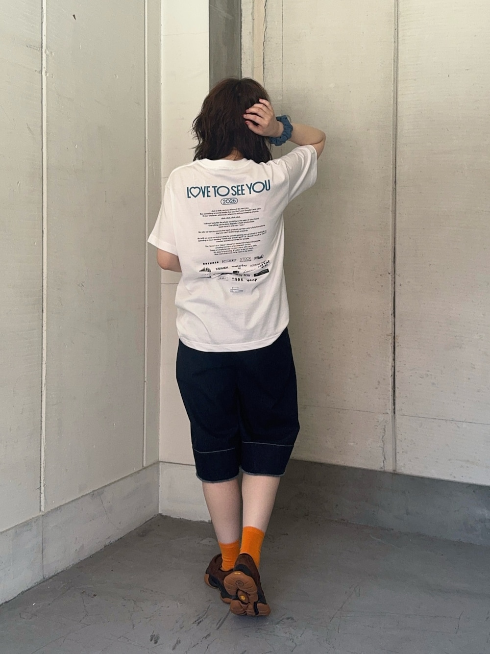 ブルー系のデニムパンツ、ブラウン系のローファーを着用したレディースの夏コーディネートの1枚目の写真
